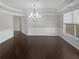 Elegant dining room with chandelier lighting, hardwood floors, and classic wainscoting at 2470 Bridle Bridge Trl, Cumming, GA 30040