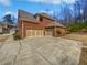 Brick home with a large driveway that leads to an attached three-car garage at 2470 Bridle Bridge Trl, Cumming, GA 30040