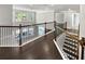 Bright hallway with hardwood floors and wrought iron railing overlooks the downstairs at 2470 Bridle Bridge Trl, Cumming, GA 30040