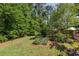 Landscaped backyard with green grass, various trees and a flowerbed at 2634 Charlesgate Ave, Decatur, GA 30030