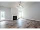 Open-concept living room featuring wood-look floors, fireplace, a ceiling fan and a back door for easy outdoor access at 267 Eason St, Bowdon, GA 30108