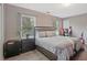 This bedroom features a bed, multiple windows, a desk, decor, and luxury vinyl plank flooring at 384 Parc River Blvd, Lawrenceville, GA 30046