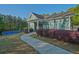 Exterior of the community clubhouse with sidewalk, tennis court and manicured landscaping at 384 Parc River Blvd, Lawrenceville, GA 30046
