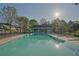 Large community pool featuring a sun deck with chairs, adjacent to a pool house at 384 Parc River Blvd, Lawrenceville, GA 30046