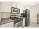 Efficient kitchen featuring stainless steel appliances, white cabinetry, and hardwood floors at 384 Parc River Blvd, Lawrenceville, GA 30046