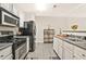 Galley kitchen featuring stainless steel appliances, white cabinetry, and hardwood floors at 384 Parc River Blvd, Lawrenceville, GA 30046