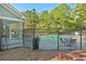 Community pool area with lounge chairs and tables surrounded by a secure black fence at 384 Parc River Blvd, Lawrenceville, GA 30046