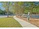 Paved walkway through a neighborhood with lush trees and a pet waste station for convenience at 384 Parc River Blvd, Lawrenceville, GA 30046