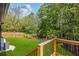 Wooden deck overlooking a spacious, grassy backyard, framed by mature trees and a wooden fence at 915 John Ward Rd, Marietta, GA 30064