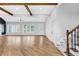 Bright living room with hardwood floors, ceiling beams, large windows and staircase with iron spindles at 915 John Ward Rd, Marietta, GA 30064