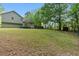 View of the home's exterior and large backyard, surrounded by mature trees offering privacy and space at 655 Poplar Rd, Dallas, GA 30157