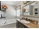Bathroom featuring a soaking tub, vanity with dark cabinets and shelving at 655 Poplar Rd, Dallas, GA 30157