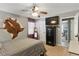 Neutral bedroom featuring ceiling fan, mounted TV, and a wall mounted cowhide at 655 Poplar Rd, Dallas, GA 30157