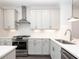 Bright kitchen features white cabinets, stainless steel appliances, and recessed lighting at 109 Iveybrooke Ln # 59, Alpharetta, GA 30009