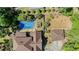 Aerial shot showcases a backyard pool, garden, and outbuildings next to the traditional home with a brown roof at 2405 Old Salem Se Rd, Conyers, GA 30013