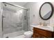 Bathroom features a shower with gray tile, framed glass doors, and an oval mirror over the vanity at 2405 Old Salem Se Rd, Conyers, GA 30013