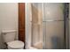 Bathroom featuring a toilet and shower with glass door, next to a wooden cabinet at 2405 Old Salem Se Rd, Conyers, GA 30013