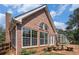 The side of this brick home features large windows, a sunroom, and a stone patio perfect for outdoor living at 2405 Old Salem Se Rd, Conyers, GA 30013