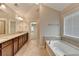 Luxurious bathroom boasts dual sinks, granite counters, tile floors and a soaking tub at 4395 Wildbrooke Pkwy, Cumming, GA 30041