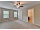 Bright bedroom with large windows, carpet, ceiling fan, neutral walls, and an ensuite bathroom at 4395 Wildbrooke Pkwy, Cumming, GA 30041