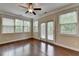 Bedroom with ceiling fan, hardwood floors, large windows, and a private balcony at 4395 Wildbrooke Pkwy, Cumming, GA 30041