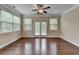 Bedroom with ceiling fan, hardwood floors, large windows, and a private balcony at 4395 Wildbrooke Pkwy, Cumming, GA 30041