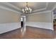 Inviting dining room with dark hardwood floors, wainscoting accents, and elegant chandelier at 4395 Wildbrooke Pkwy, Cumming, GA 30041