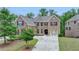 Charming two-story brick home with lush front yard landscaping, a three-car garage, and double driveway at 4395 Wildbrooke Pkwy, Cumming, GA 30041