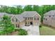 Stately brick home with a meticulously landscaped front yard, complemented by a three-car garage and inviting entryway at 4395 Wildbrooke Pkwy, Cumming, GA 30041