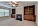Living room featuring a fireplace, built in cabinets and a window with a view of the outdoors at 4395 Wildbrooke Pkwy, Cumming, GA 30041