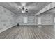 Unfinished living room with laminate floors, ceiling fans, and natural light from windows at 4395 Wildbrooke Pkwy, Cumming, GA 30041