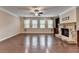 Open living room with hardwood floors, a stone fireplace, and natural light at 4395 Wildbrooke Pkwy, Cumming, GA 30041
