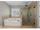 Bathroom featuring a soaking tub, glass enclosed shower, and large window offering ample light at 4631 Crooked Creek Ln, Villa Rica, GA 30180