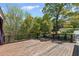 Large wooden deck offers a scenic view of the well-manicured lawn and mature trees at 4631 Crooked Creek Ln, Villa Rica, GA 30180