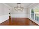 Elegant dining room with hardwood floors, decorative molding, a modern chandelier, and large windows at 4631 Crooked Creek Ln, Villa Rica, GA 30180
