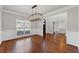Bright dining room showcasing hardwood floors, a modern light fixture, and classic white trim and wainscoting at 4631 Crooked Creek Ln, Villa Rica, GA 30180