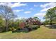 Beautiful two-story brick home set on a lush green lawn with mature trees and manicured landscaping at 4631 Crooked Creek Ln, Villa Rica, GA 30180