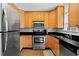 Functional kitchen with stainless steel appliances, wooden cabinets, and sleek black countertops at 1211 Argonne Ne Way, Atlanta, GA 30324