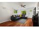 Cozy living room with hardwood floors, ceiling fan, and a comfortable black leather sofa at 1211 Argonne Ne Way, Atlanta, GA 30324