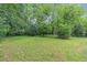 Spacious backyard featuring lush green lawn and mature trees at 1766 Sw Brewer Sw Blvd, Atlanta, GA 30310