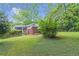 Lush backyard featuring green grass and mature trees surrounding a brick house at 1766 Sw Brewer Sw Blvd, Atlanta, GA 30310