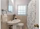 Cozy bathroom featuring a pedestal sink, neutral tile, and a window providing natural light at 1766 Sw Brewer Sw Blvd, Atlanta, GA 30310