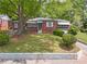 Lovely brick house featuring a green lawn, shade trees, and an attached garage at 1766 Sw Brewer Sw Blvd, Atlanta, GA 30310