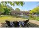 Beautiful exterior view of townhomes overlooking a pond with a fountain and seating area at 200 River Vista Dr # 236, Atlanta, GA 30339