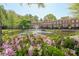 Beautiful exterior of townhomes with a decorative water feature surrounded by pink flowers at 200 River Vista Dr # 236, Atlanta, GA 30339