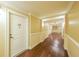Well lit hallway with wood flooring, with light walls and white trim in condo building at 200 River Vista Dr # 236, Atlanta, GA 30339