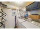 Efficient laundry room with washer, dryer, shelving, vacuum and drying rack for convenience at 200 River Vista Dr # 236, Atlanta, GA 30339