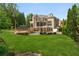 A lush green lawn and landscaped backyard features a pool, patio, and outdoor seating at 3215 Oxleas Ct, Cumming, GA 30041