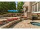 An eye-level view of a backyard with stone patio, hot tub and a raised dining area at 3215 Oxleas Ct, Cumming, GA 30041