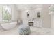 Bright bathroom features a soaking tub below a stained-glass window, double vanity, and marble floors at 3215 Oxleas Ct, Cumming, GA 30041